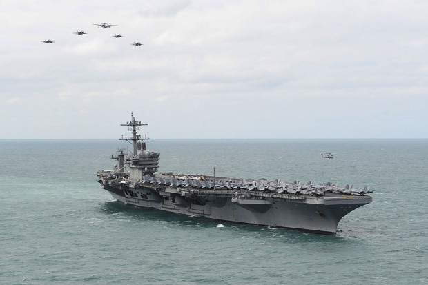 US Aircraft from Carrier Air Wing 1 fly in formation over the Nimitz-class aircraft carrier USS Theodore Roosevelt during an airpower demonstration. Theodore Roosevelt has anchored off Portsmouth as part of a round-the-world deployment. [Picture: U.S. Navy photo by Mass Communication Specialist 3rd Class Anthony N. Hilkowski] 