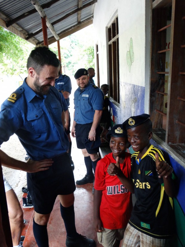 A Portsmouth based warship has taken time out from her counter terrorism/piracy operations to provide a helping hand at an orphanage in Dar es Salaam, Tanzania. Between taking on supplies and hosting local dignitaries, a number of the ships company volunteered to help out at the Kids Care Orphanage. The visit was led by Sub Lieutenant Jo Peacock, who said: Weve provided basic medical care, and helped to repair orphanage equipment, including their water pump and bicycles.  With medical and engineering expertise onboard, it was rewarding to use these skills to help the children. HMS Richmonds medical officer Surgeon Lieutenant Robert Woodward, who ran a clinic at the orphanage, added: The most important part of the medical care we provided was education to staff and children about malaria and other diseases. Its this knowledge which will continue to make a difference after we have left. Meanwhile, the ships Leading Physical Trainer (LPT) Ollie Osborne, helped clear the local football pitch, and donated some sports equipment including footballs and England shirts, for use by the orphanage.  LPT Osborne said: It was genuinely moving seeing what opportunities were being provided to the children by the orphanage.  I hope that the pitch we helped clear, and the footballs provided will encourage the kids to make team sport and the physical discipline that it brings an enjoyable part of their childhood.  HMS Richmond is deployed to the Indian Ocean as part of Combined Maritime Forces Combined Task Force 150 (CTF150), their mission is to promote maritime security in order to counter terrorist acts and related illegal activities. Pictured: Lt Paul Holland donates his cap to a youngster