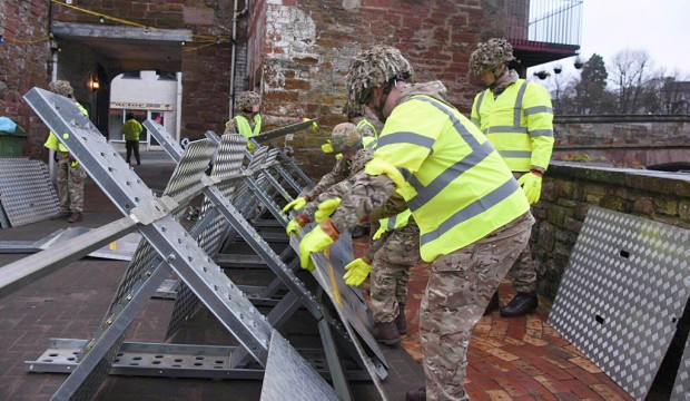 The Army has been called in to support efforts to protect flood-hit areas of Cumbria amid fears that more heavy rain will fall on Christmas Day. People are set to spend the day putting out sandbags in preparation and flood defence gates have been closed in Cockermouth, Carlisle and Keswick. Cumbria has suffered severe flooding three times this month. The Ministry of Defence said one company from 2nd Battalion Duke of Lancaster's Regiment (2LANCS), based at Weeton Barracks near Preston, are being deployed to affected areas on Christmas Day morning. Rain will spread across Wales and northern England through the course of Christmas Day, reaching southern parts of Scotland during the early hours of Boxing Day, with prolonged spells forecast for south Cumbria. The county has already recorded the wettest December since records began in 1910. Defence Secretary Michael Fallon said: "Even at Christmas our Armed Forces are keeping us safe. Once again they are responding to the Cumbria floods with a level of commitment that is to be applauded." Pic - Soldiers from 2LANCS help set up flood defences in Appleby.