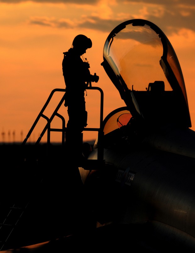A Royal Air Force Typhoon pilot enters the cockpit as the sun sets over Gioia del Colle, southern Italy. As RAF Typhoon aircraft play a greater part in deliberate targeting operations, where targets are pre-planned, more are carrying four of the 1000lb Enhanced Paveway II bombs. The aircraft's ability to use its Litening III targeting pod to direct the highly accurate bombs means that a single Typhoon can have a devastating effect on Qadhafi regime targets.