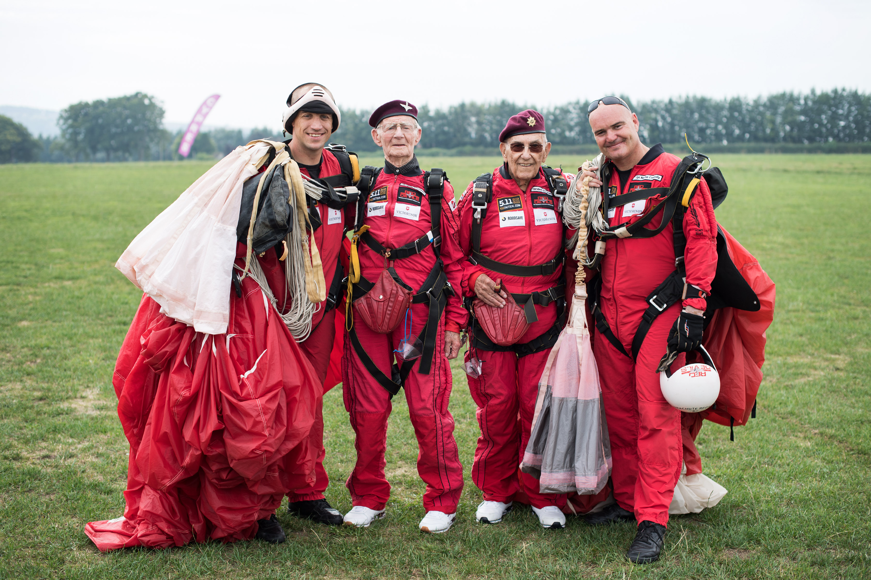 Fred Glover and Ted Pieri, two D-Day veterans who are both 90 years old pose for a group photograph with members of the Red Devils Parachute display team after they parachuted into Sarum Airfield, Wiltshire, 72 years after D-Day having earlier in the month jumped into Merville Battery in France.