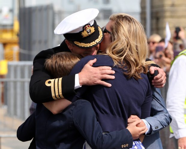 Pictured: Commander Hutchings, CO of HMS St.Albans, welcomed home by his family.