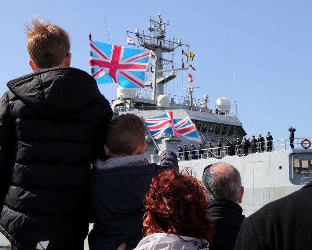 Two children wave union jacks to welcome home HMS Enterprise back to the UK after it's epic 35 month deployment around the world.