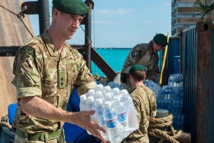 A Royal Marine unloading water supplies for residents of Grand Turk from an aid boat as part of the UK military response to Hurricane Irma. Crown copyright.