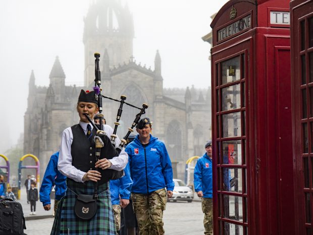 A Legion Scotland piper leads the procession up the Royal Mile. Crown copyright.