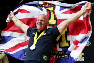 Dot Perkins waves a Union Jack while wearing a silver medal