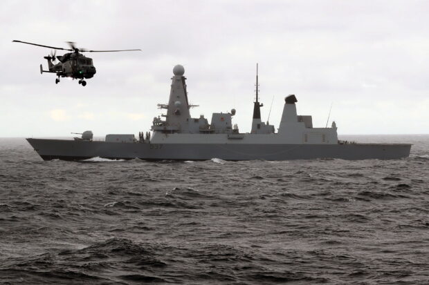 HMS Duncan at sea with a Wildcat helicopter.