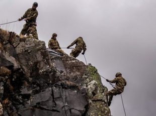 Royal Marines abseiling from a cliff