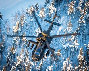 An Apache flying over snow