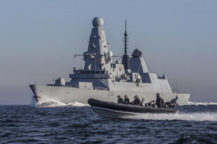 HMS Defender at sea with one of her seaboats