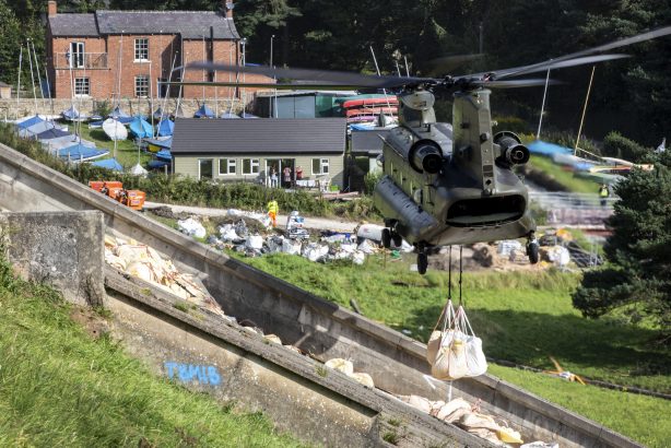 An RAF Chinook hovers over a dam in response to the emergency at Whaley Bridge 