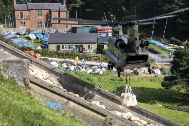 An RAF Chinook hovers over a dam in response to the emergency at Whaley Bridge 