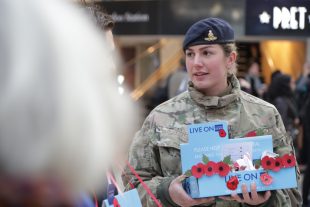 Troops and veterans selling poppies to the public at Waterloo Station during London Poppy Day